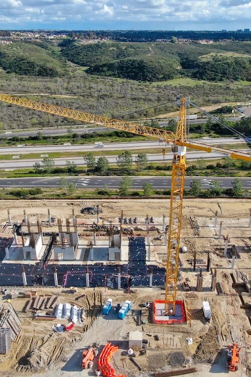 Aerial view of new construction site with crane and building materials.