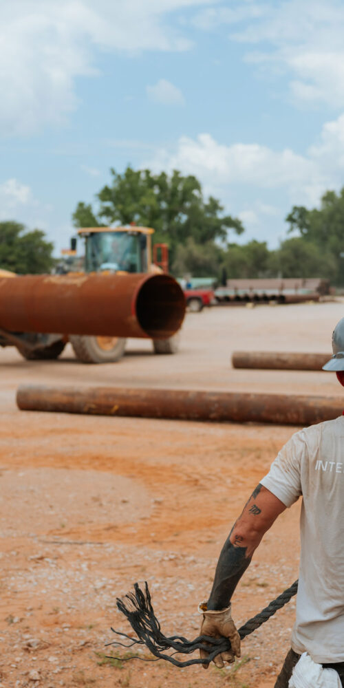 man walking in pipe yard