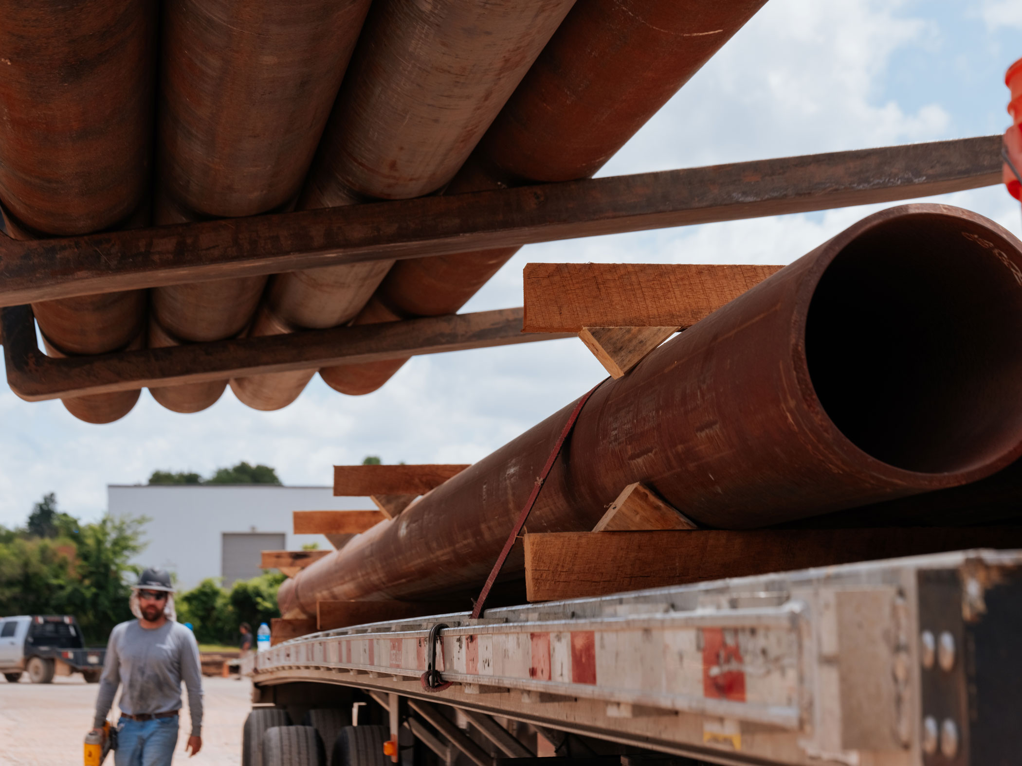 semi-truck bed full of large pipe