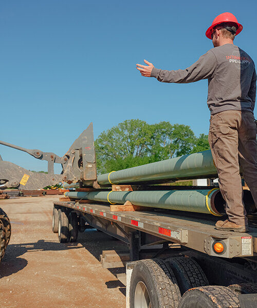 International Pipe Employee next to pipe